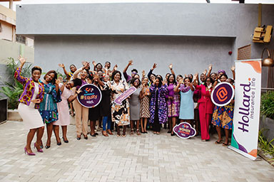 Hollard women gathered together at the Hollard Women High Tea holding “Embrace Equity” signs